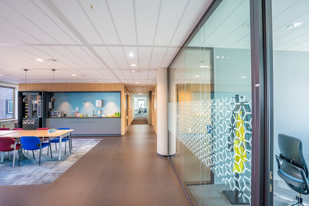 The 630 Area A sleek modern office space featuring colorful seating and a kitchenette in a bright, well-lit environment.