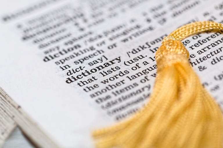 Juntos Seguros ICE: Understanding the Program, Its Purpose, and Community Impact Newstook Close-up image of a dictionary page focused on the word 'dictionary' with a yellow tassel.