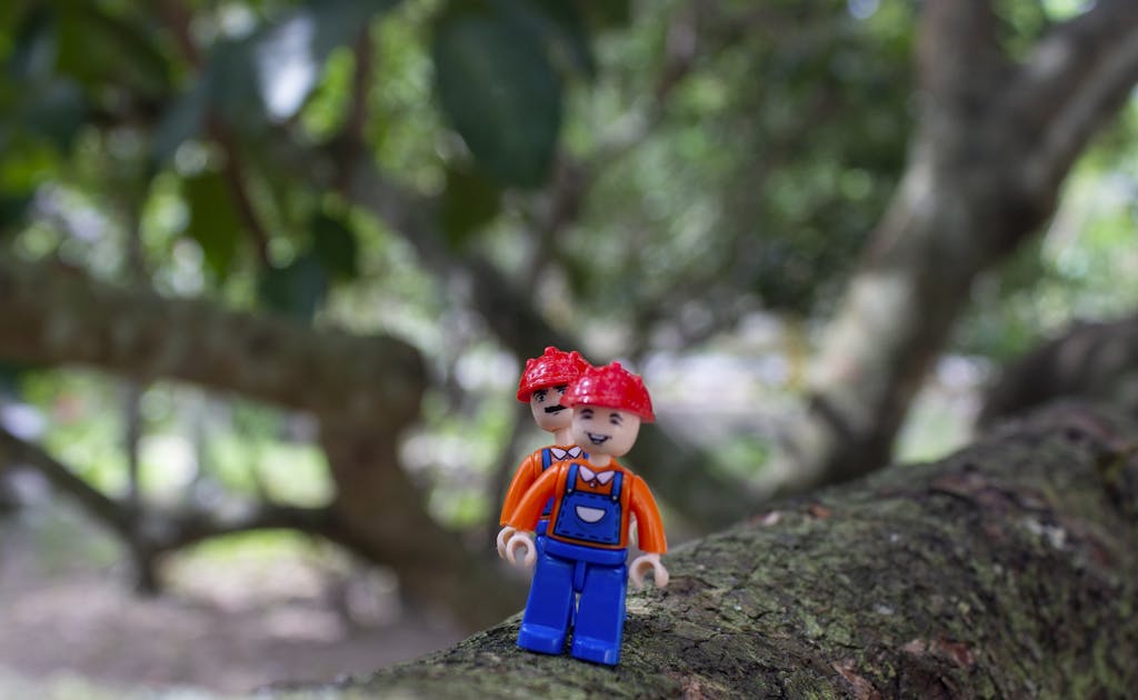 Shop Sunnylife Giant Jumbling Tower Colorful LEGO figure on tree branch, blending creativity with nature.