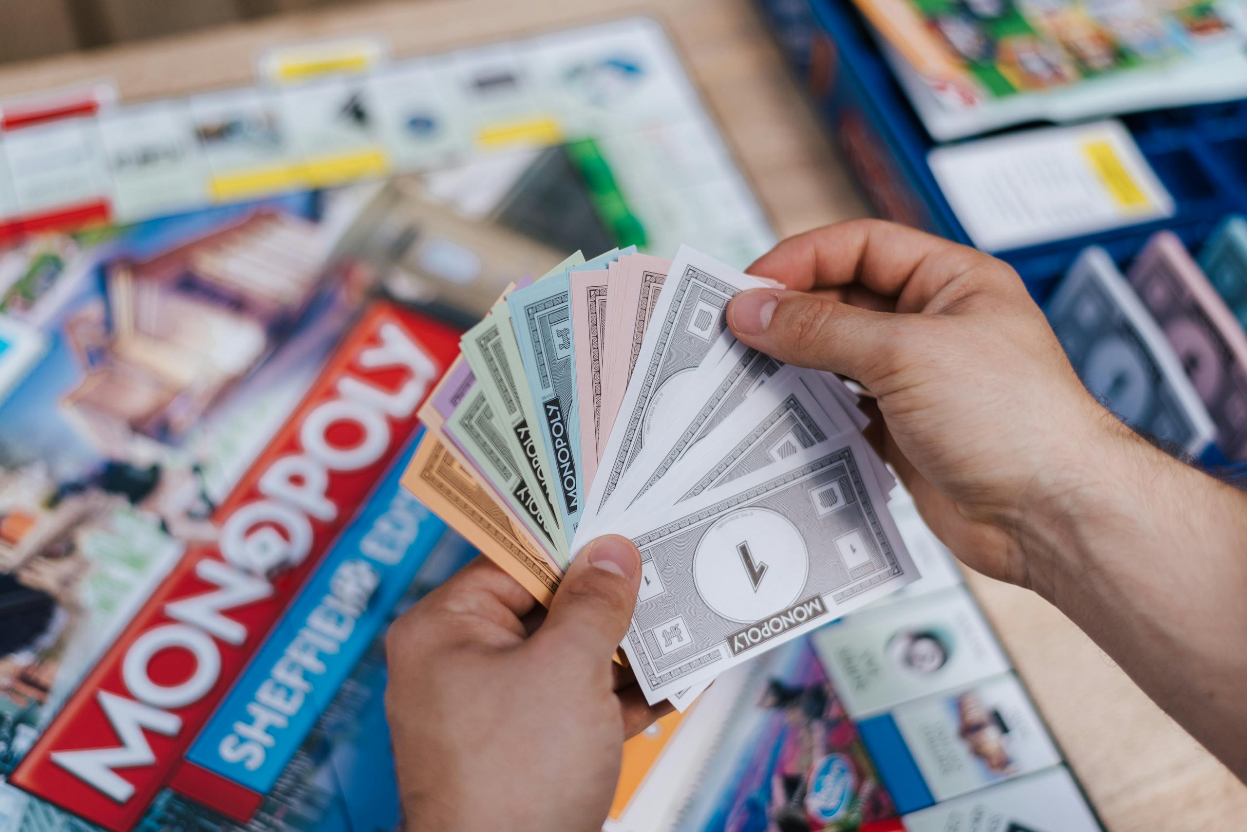 Florida Woman Wins Monopoly Lottery From above of crop anonymous man with set of game money playing Monopoly above board