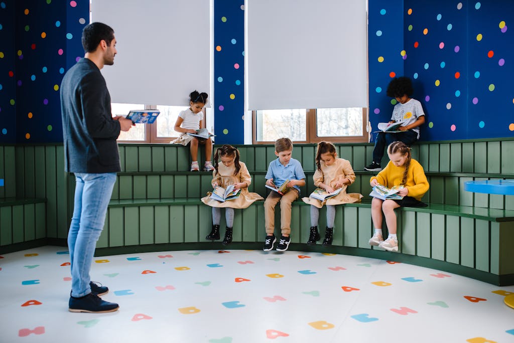 JoinMyQuiz Kids and teacher reading together in a vibrant, polka dot classroom.