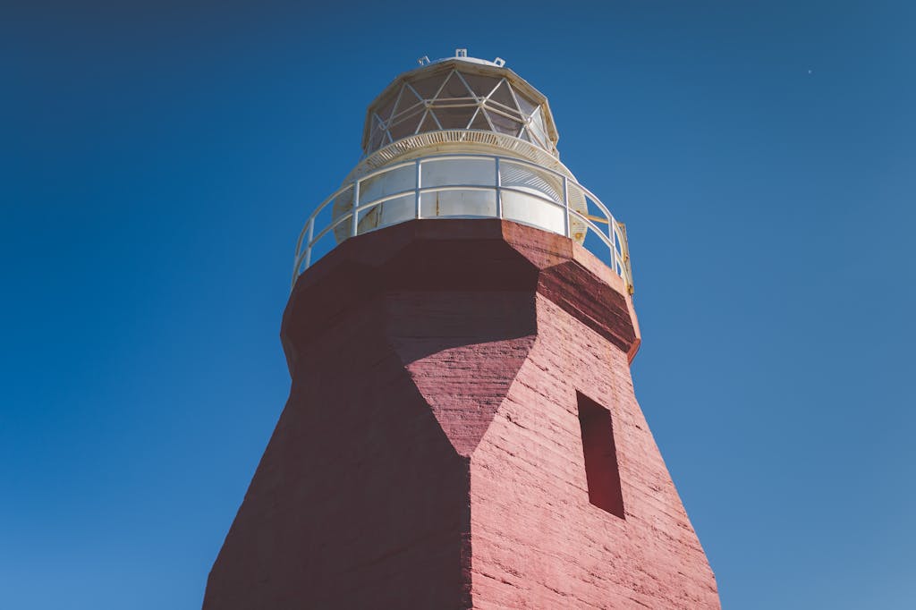 VRealize Infrastructure Navigator Low angle view of a red lighthouse with a blue sky, showcasing architecture and vibrant contrast.
