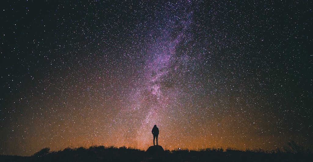 Pappedeckel Person silhouetted against a breathtaking night sky filled with stars and the Milky Way galaxy.