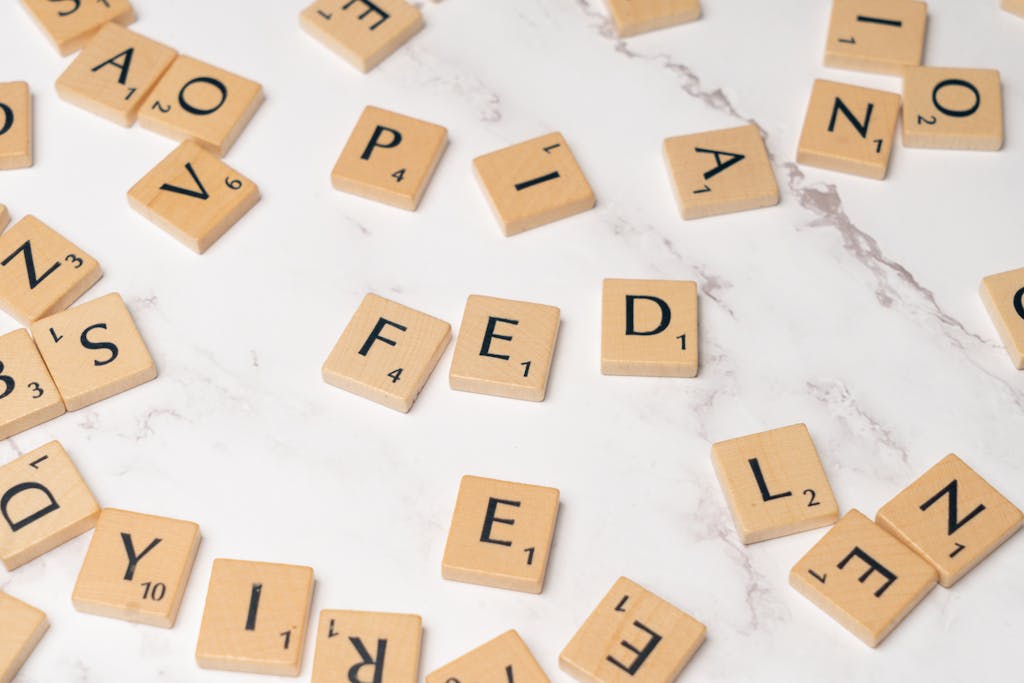 Juntos Seguros Scrabble tiles arranged to spell 'FED' on a marble surface, symbolizing finance.