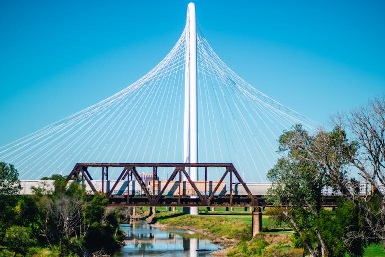 Texas Hunting Forum View of the Margaret Hunt Hill Bridge with a train passing underneath in Dallas, Texas.