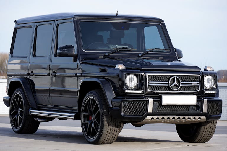 Unbanned G+Sleek black Mercedes G-Class SUV parked outdoors, showcasing luxury design and power.