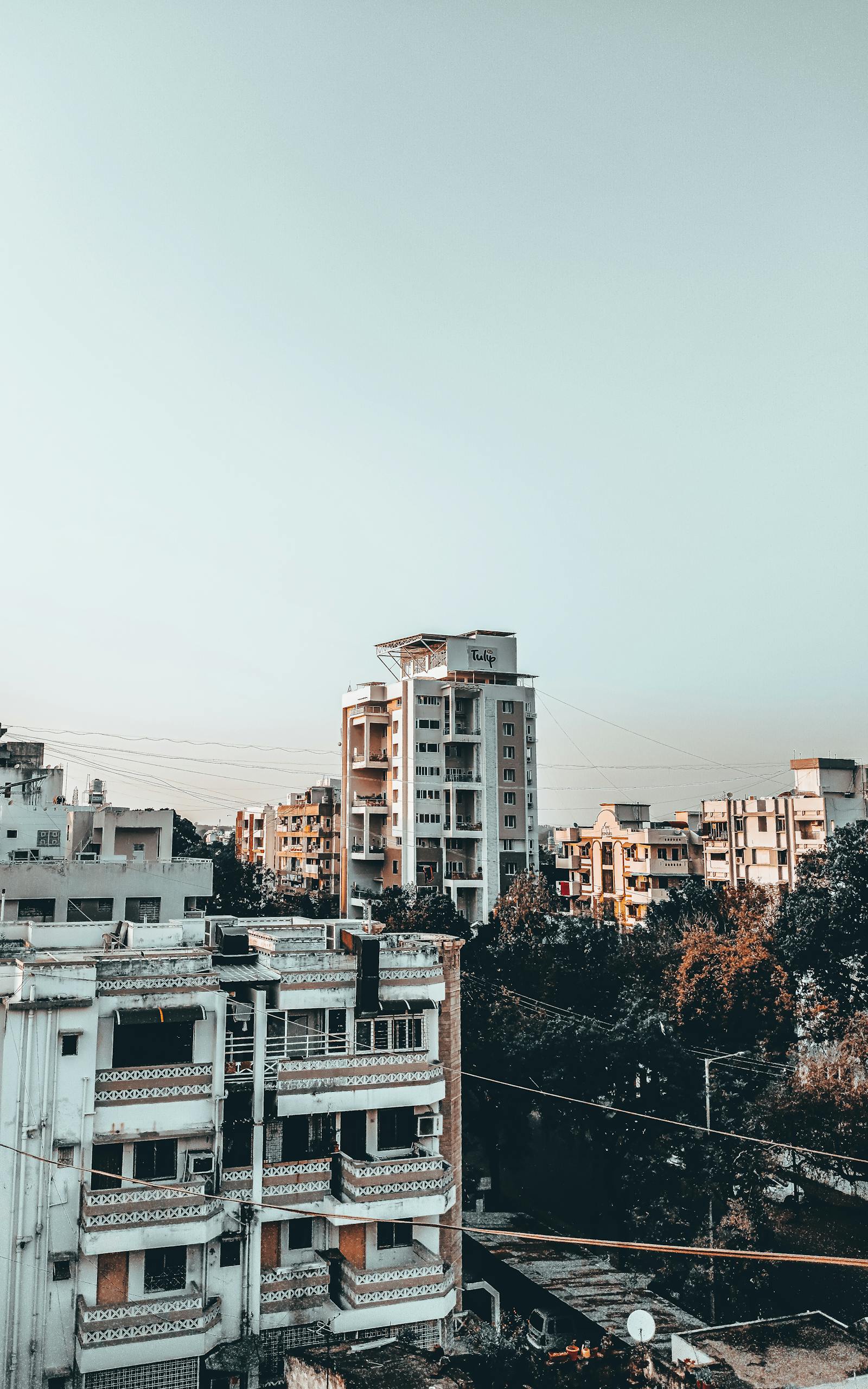 rajkot updates news Aerial view of urban apartment buildings with a clear sky, showcasing modern architecture.