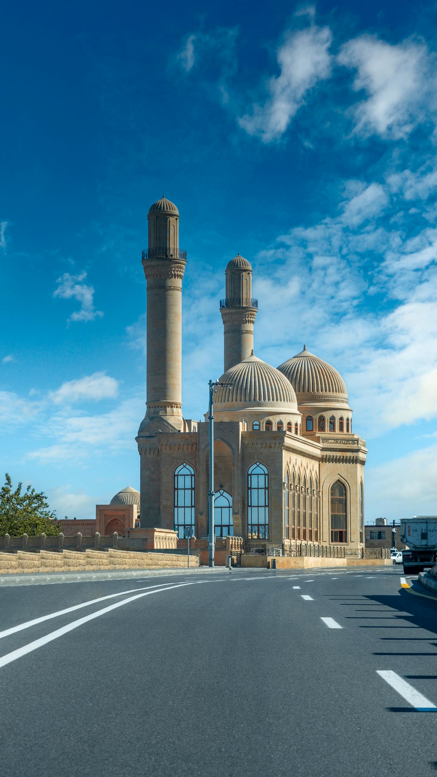 Voozon Bibi Heybat Mosque in Baku, Azerbaijan, with its iconic domes and minarets against a bright blue sky.