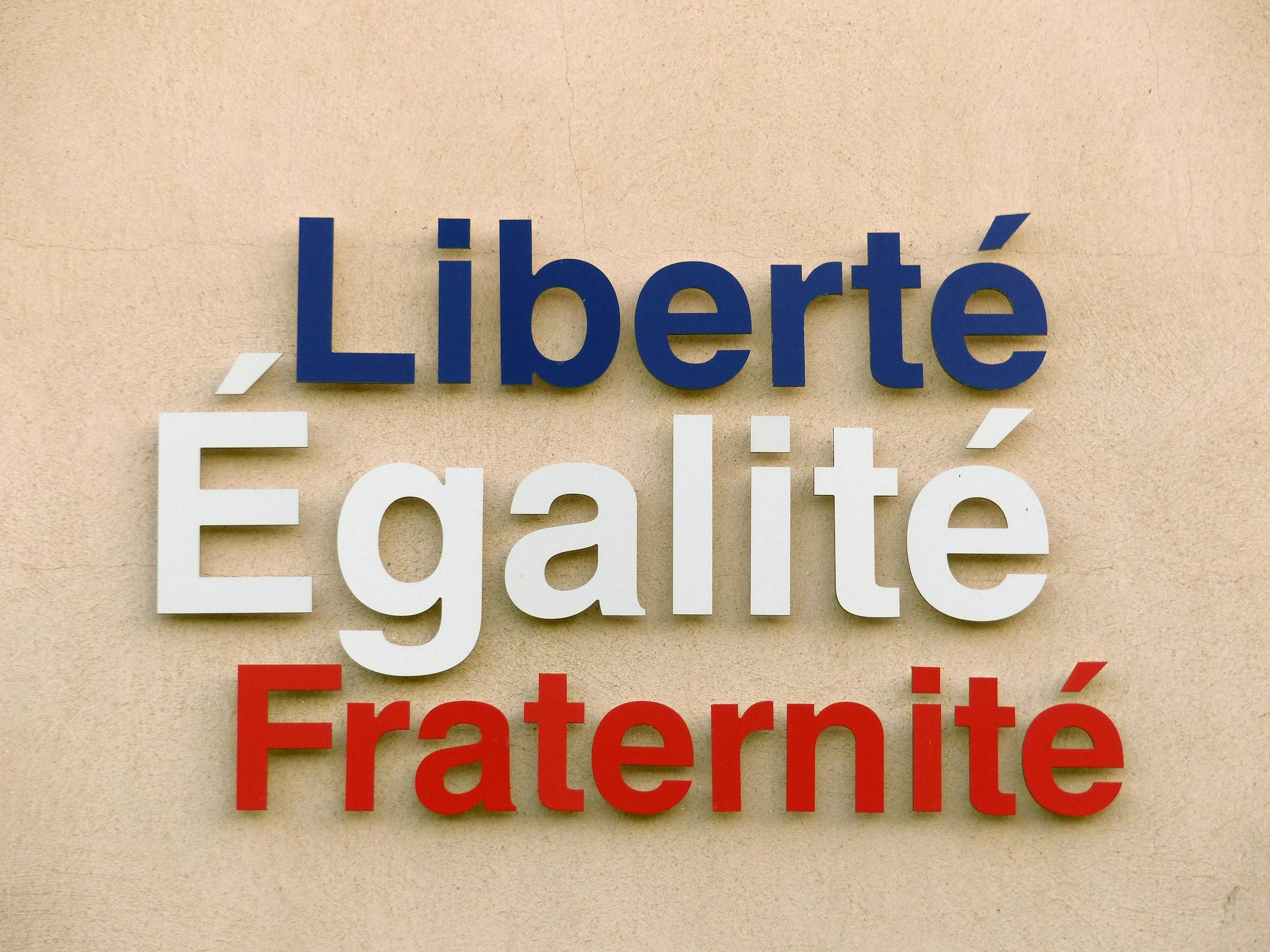 IPLLeague2026 Bold text of 'Liberté, Égalité, Fraternité' on a wall in France.