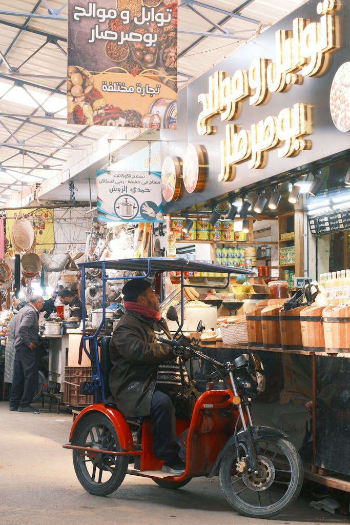 Voozon Colorful local market in Sfax, Tunisia with a man on a scooter, showcasing vibrant cultural diversity.