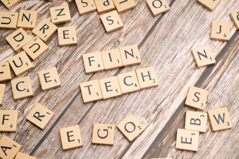 FintechAsia Fintech spelled out with wooden letter tiles on a rustic wooden background.