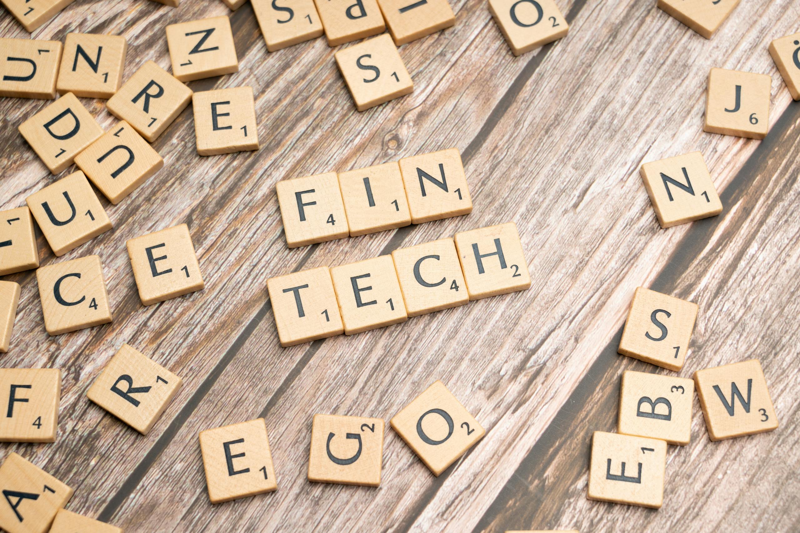 FintechAsia Fintech spelled out with wooden letter tiles on a rustic wooden background.