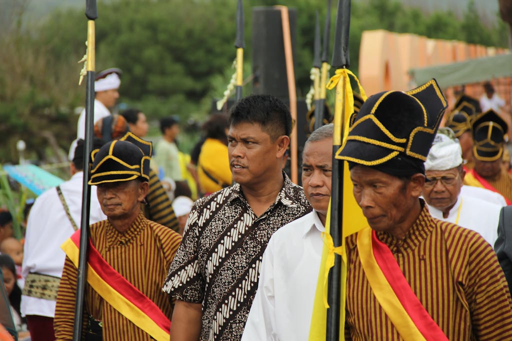 Dojen Moe Group of men participating in a traditional ceremony wearing cultural attire and holding spears.