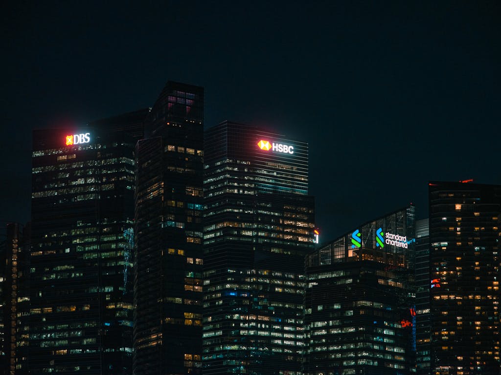 FintechAsia Illuminated city skyscrapers of major banks in Singapore's financial district at night.