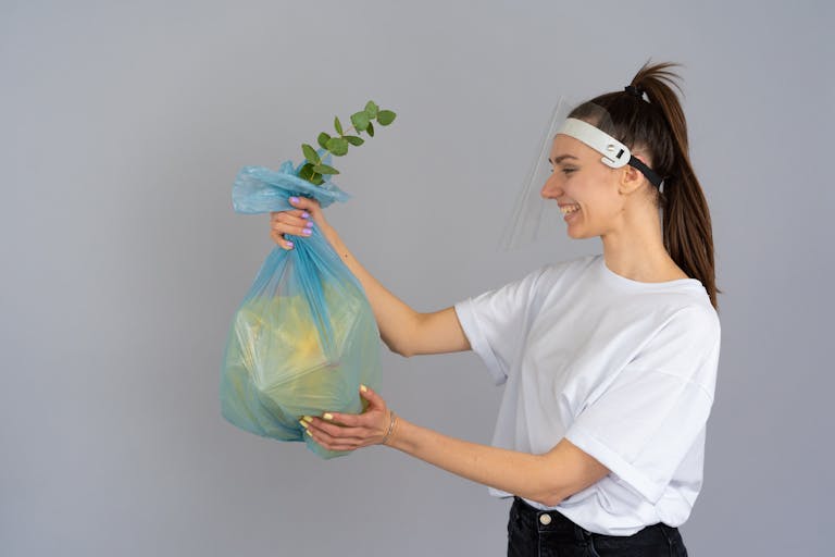 Matarecycler Smiling woman holding a recyclable bag with a plant, promoting eco-friendly practices.