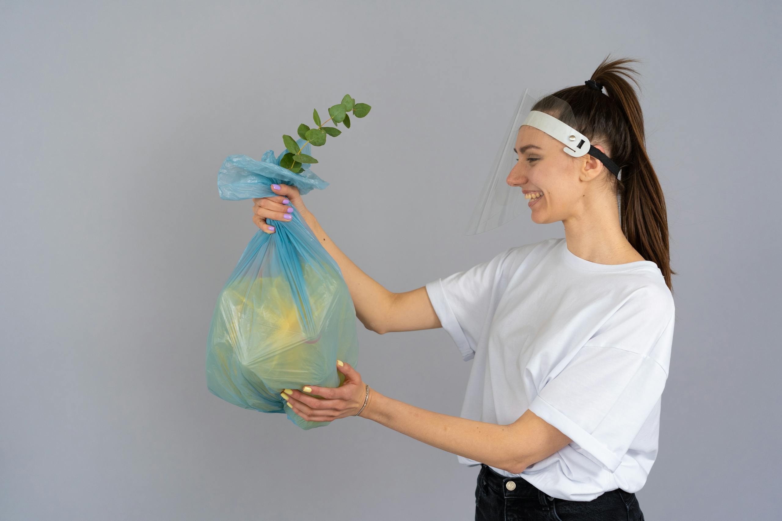 Matarecycler Smiling woman holding a recyclable bag with a plant, promoting eco-friendly practices.