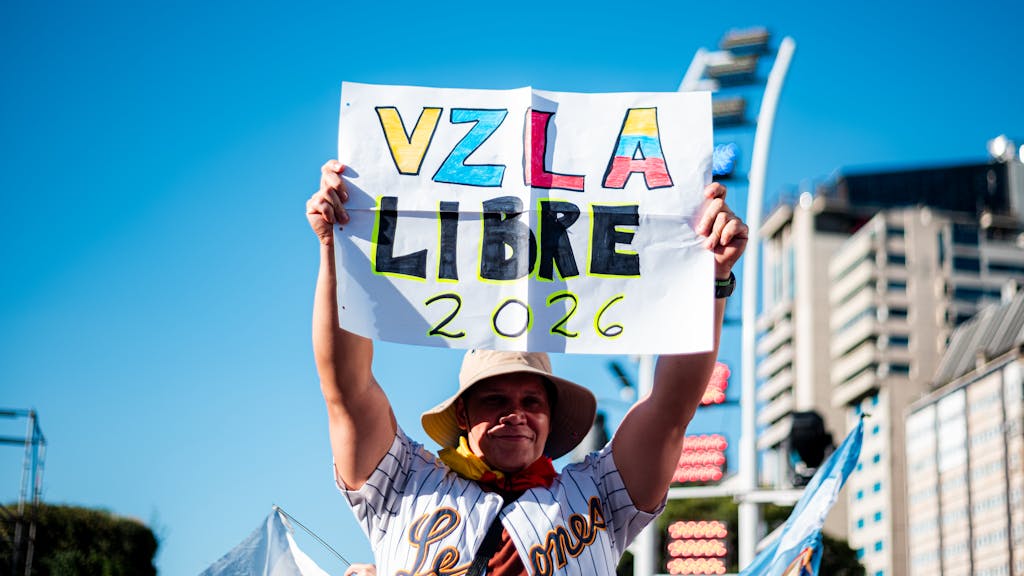 Venezuelan cIPLLeague2026 ommunity in Buenos Aires celebrates freedom with signs and flags.